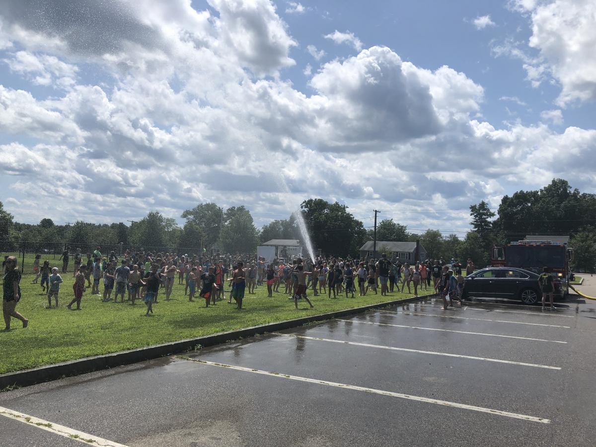 Large Group of D.A.R.E Kids Playing with the Water Hose