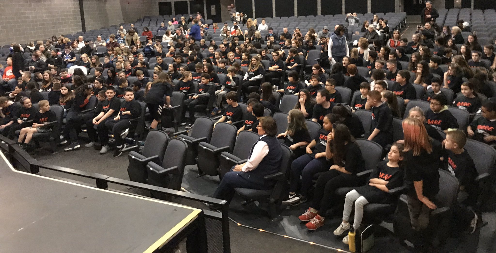 Kids Sitting at an Auditorium Wearing D.A.R.E Shirts